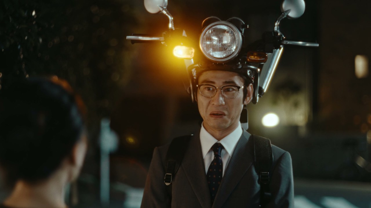 夜道で、頭に載ったバイクのウインカーを光らせる男性